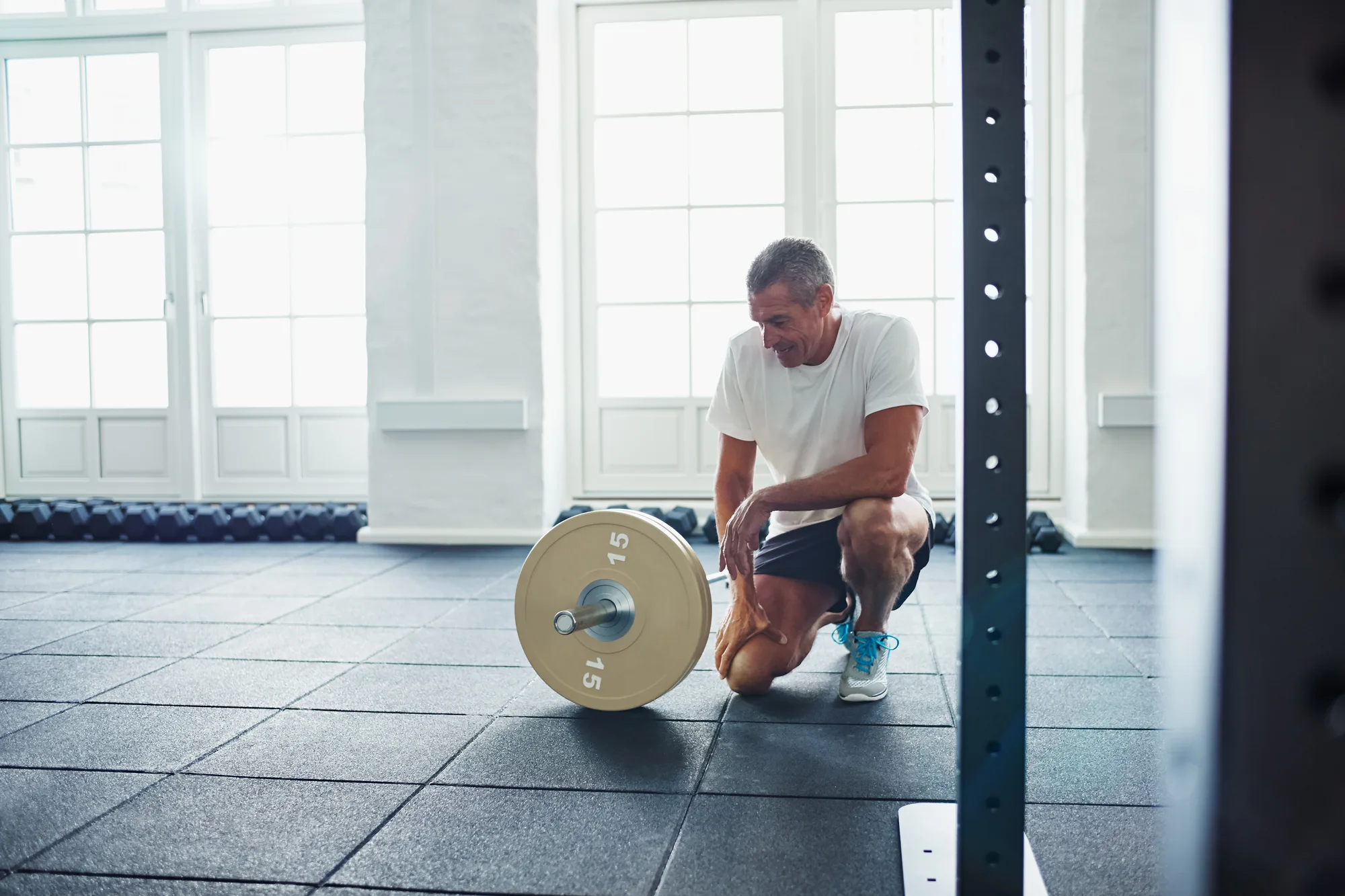 Mature man taking a break from working out with weights