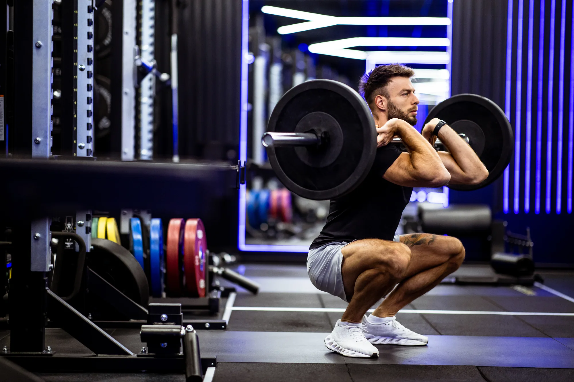 Weightlifting session in a modern gym with bright lighting and colorful weights