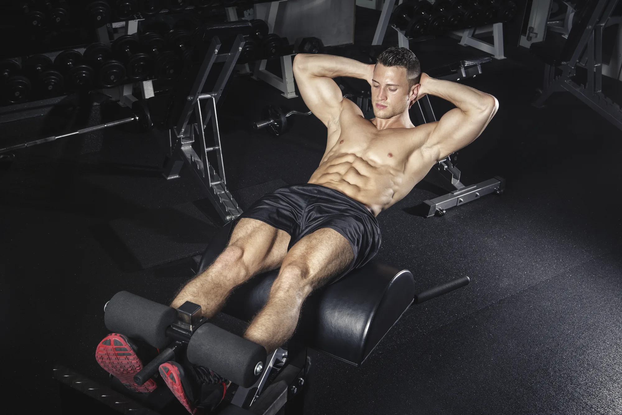 Physical athlete exercising with glute ham developer