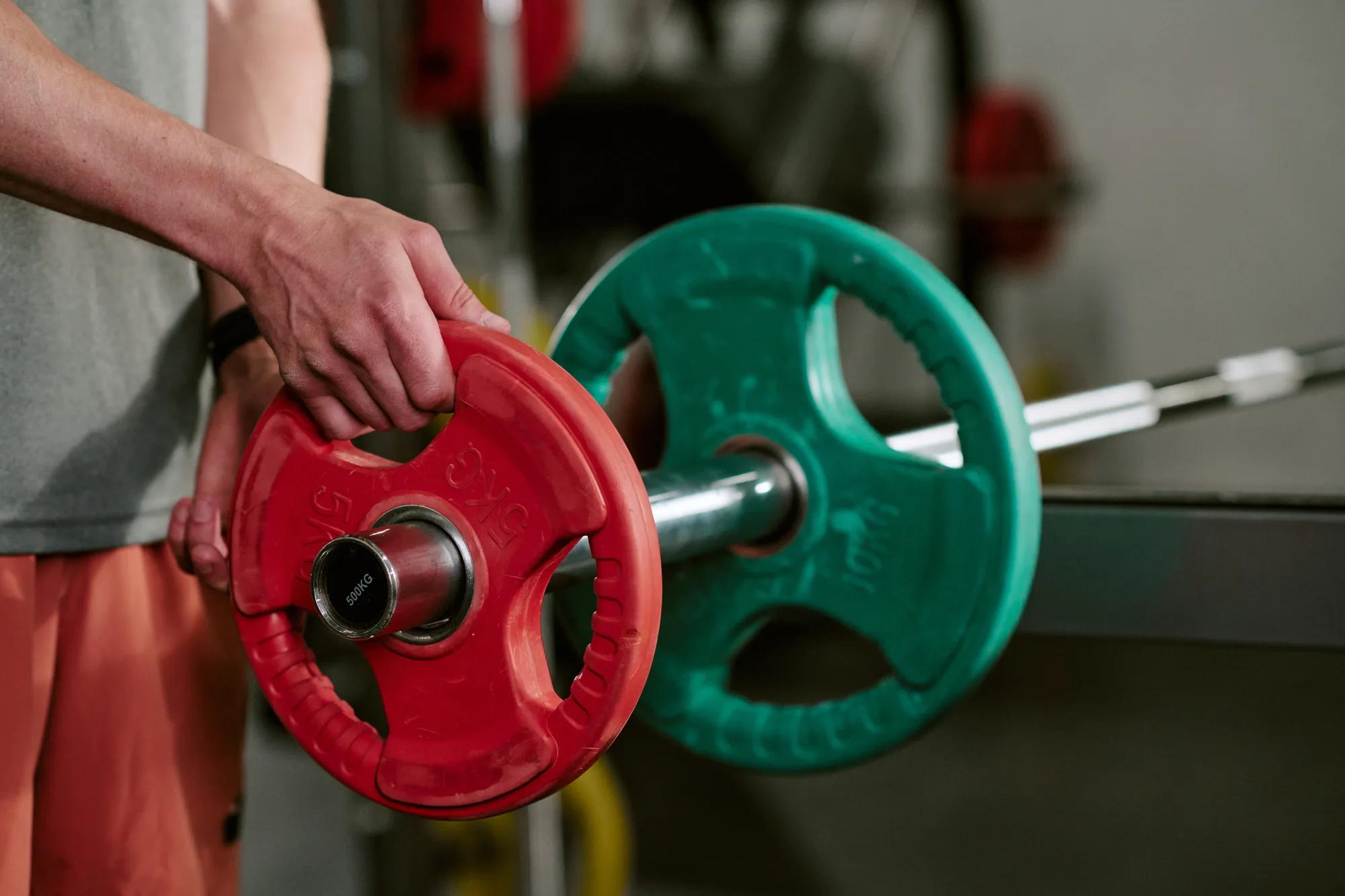 Man Loading Barbell Plates during Strength Training